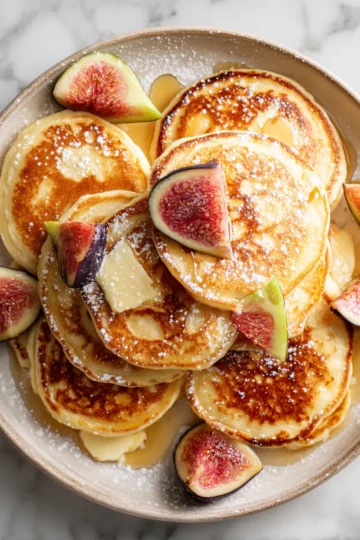 Pancakes esponjosos dorados y suaves ideales para un desayuno acogedor en casa.