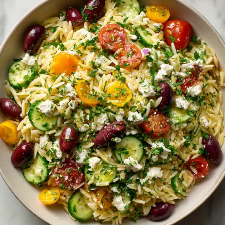 Ensalada fresca de orégano con orzo, vegetales y queso feta, ideal para el verano y picnics. Sabor mediterráneo en cada bocado.