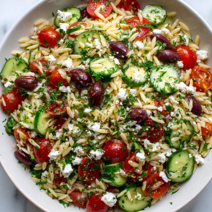 Ensalada fresca de orégano con orzo, vegetales y queso feta, ideal para el verano y picnics. Sabor mediterráneo en cada bocado.