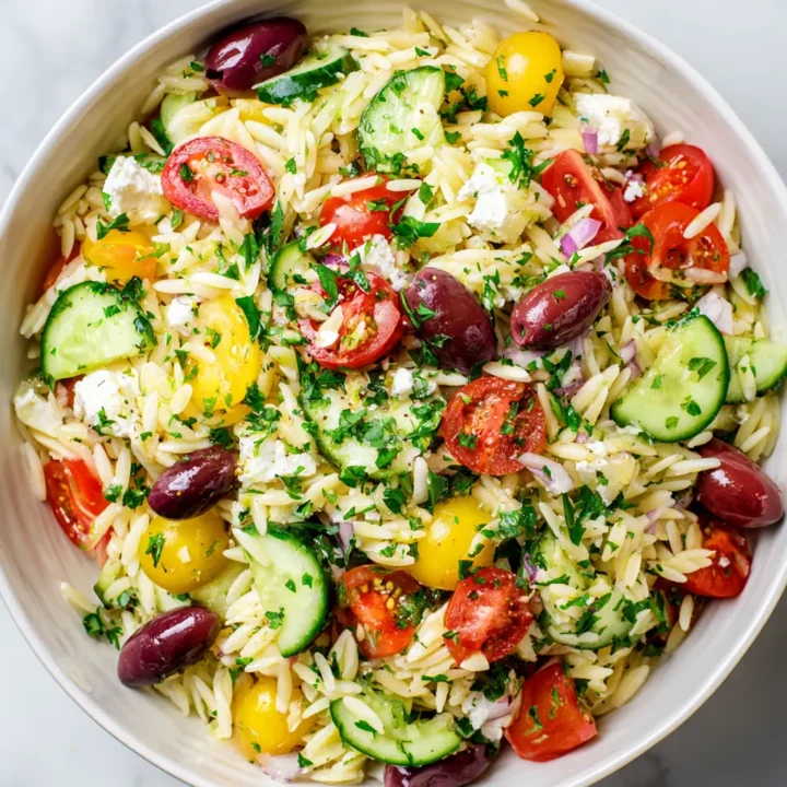 Ensalada fresca de orégano con orzo, vegetales y queso feta, ideal para el verano y picnics. Sabor mediterráneo en cada bocado.